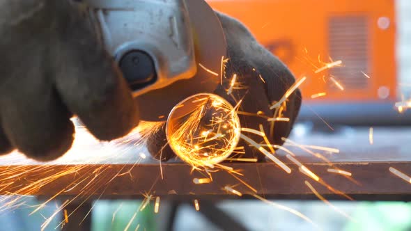 Detail View on Metal Processing with Circular Saw. Hands of Mechanic Holding Instrument and Grinding alt