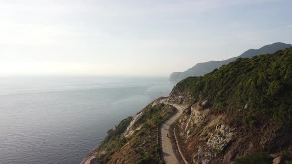 Aerial Scenic View of a Cliffside Curvy Road in a Tropical Island on Summer Day alt