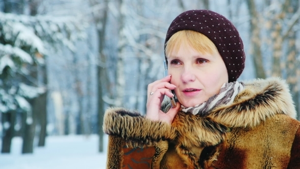 A Woman In a Fur Coat Talking On a Mobile Phone alt