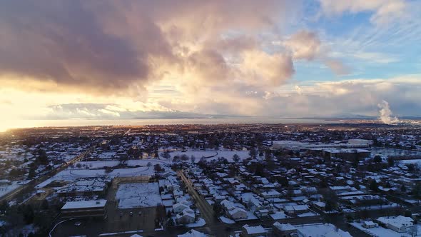 Hyper lapse flying over snow covered neighborhood towards sunset alt