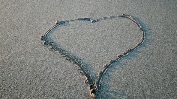 Heart Drawn on The Sand Erasing Wave