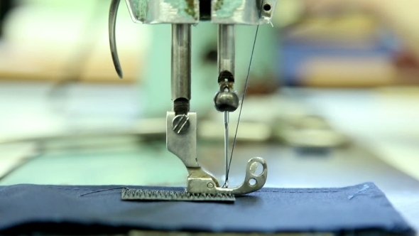Woman Sews Clothes In a Sewing Workshop