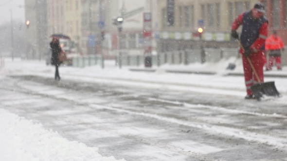 Woman Walking On Frozen Pavement During Snow Storm alt