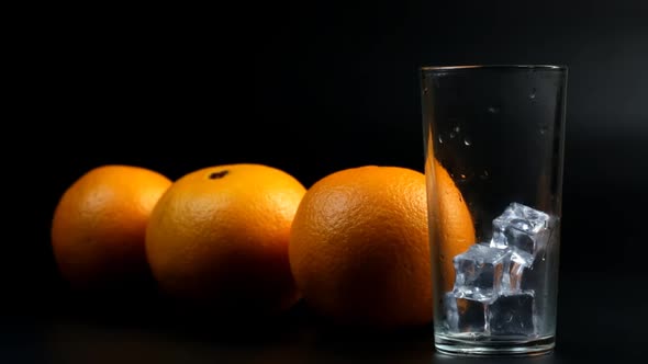 Pour Orange Juice And Three Oranges In A Tall Glass With Ice