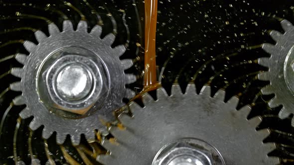 Super Slow Motion Shot of Gear Mechanism and Oil on Dark Background at 1000 Fps alt