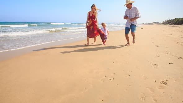 Little Girl Mother in Red Grandpa Run by Foamy Surf along Beach alt
