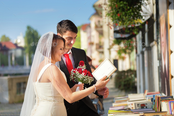 Beautiful wedding couple reviewing vintage books.