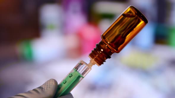 Close up of a syringe with vaccine. Close up of a flask with vaccine. 