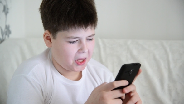  Boy Plays On The Smartphone And Laughing
