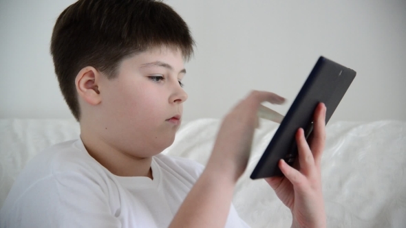 Teen Boy Enjoys  Tablet Indoors