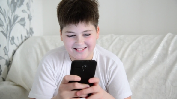  Boy Plays on The Smartphone and Laughing