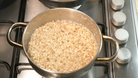 The Pan On The Cooking Stove. Barley Porridge Cooked In The Pan. alt