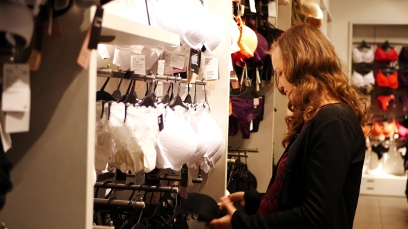 Young Woman Chooses a Bra In Lingerie Store