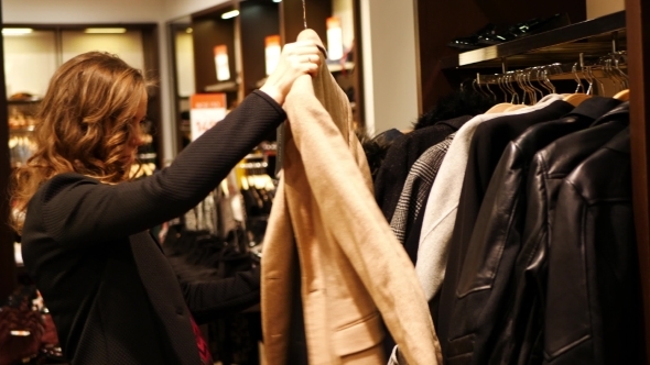 Women Choose Coat In a Clothing Store alt