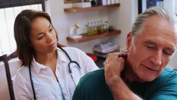 Senior man receiving neck massage from physiotherapist alt
