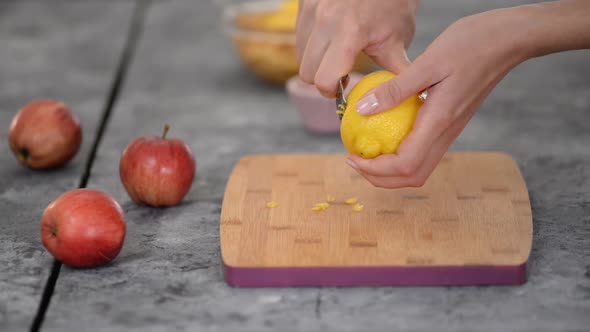 Female Hands Peels a Lemon Zest with Peeler