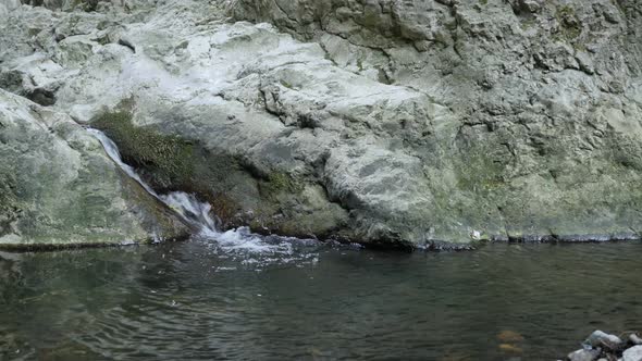 Zooming-out on water spring   cascades close-up 4K 2160p 30fps UltraHD footage - Stone bridge in Eas