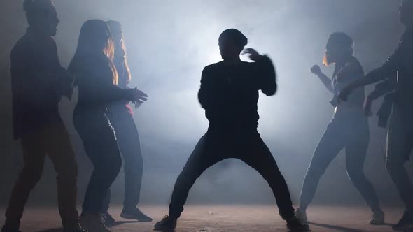 Group of Street Dancers Performing Different Moves on Dark Street alt