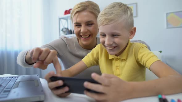 Mother and Little Son Playing Together New Game on Smartphone, Leisure Time, App