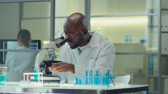 African American Scientist Working with Microscope in Lab alt