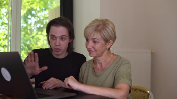 Joyful Adult Woman and Guy are Studying with Laptop at Home