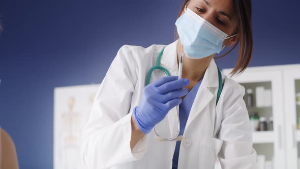 Handheld video of female doctor giving shot to patient. Shot with RED helium camera in 8K. alt