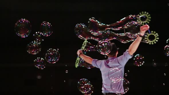 The Man the Actor is Turned and Sprays Big Soap Bubbles By Means of Forms alt