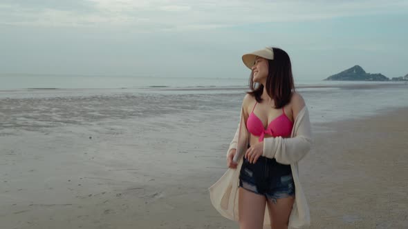 cheerful woman in bikini walking on the sea beach alt