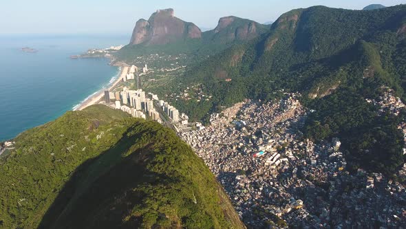 Aerial Drone Shot Following a Mountain Ridge Revealing the Ocean and Condos in Rio De Janeiro Brazil alt