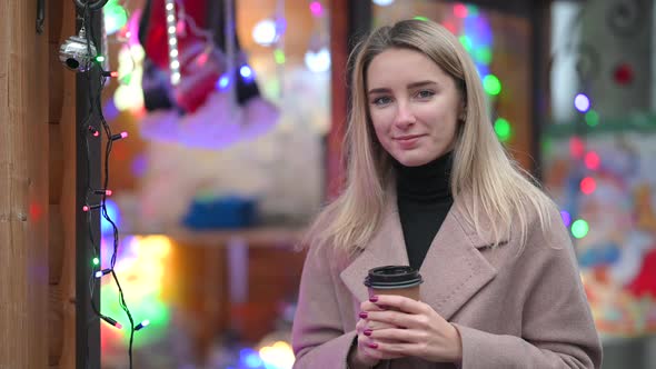 portrait of a smiling young girl with a cup of hot coffee
