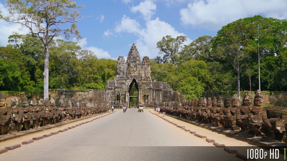 Bayon Angkor Thom Entrance Gate as Tourists Walk and Ride by alt
