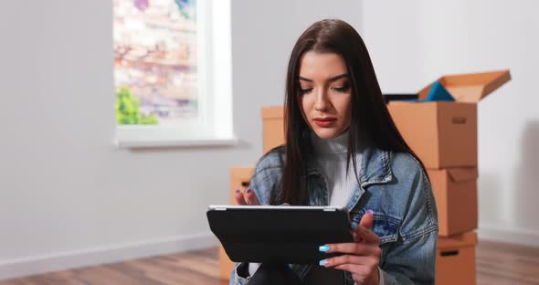 Happy Beautiful Young Woman Sitting on the Floor in New Apartment and Thinking About Future alt