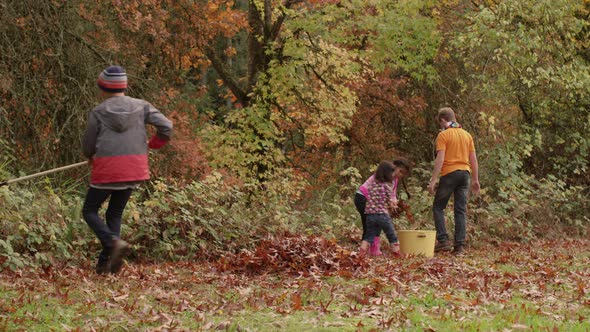 Group of kids in Fall raking leaves
