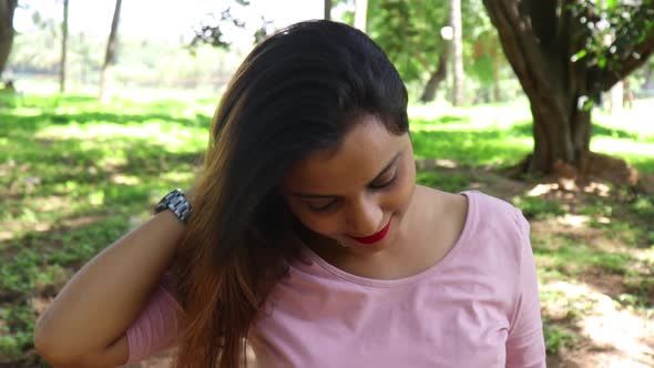 Slow motion video of beautiful Indian woman smiling and looking at the camera after playing with her alt