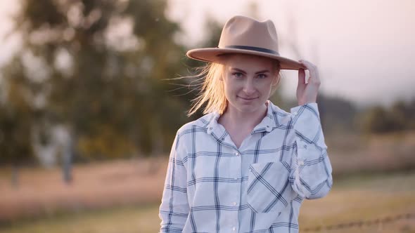 Female Modern Farmer Smiling and Looking Into Camera While Wearing Hat alt