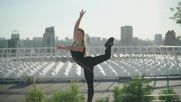 Camera Approaches To Flexible Ballet Dancer Standing on One Leg and Looking at Camera. Slim alt