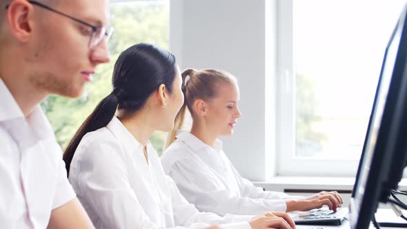 Diverse team of young professionals is working in the phone support office. alt