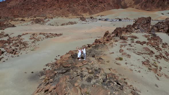 A Couple Stands on a Rock in the Crater of the Teide Volcano a Lunar Landscape on the Island of
