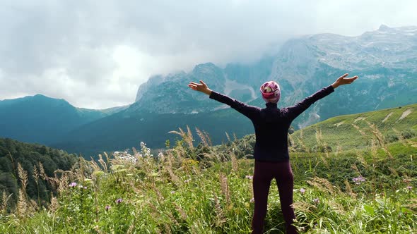 Woman Hiker Raises Hands Up in Mountains Enjoying Beautiful View and Surrounding Wild Nature alt