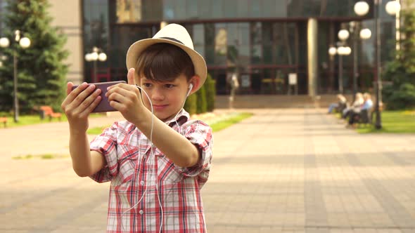 Little Boy Takes a Selfie Outdoors