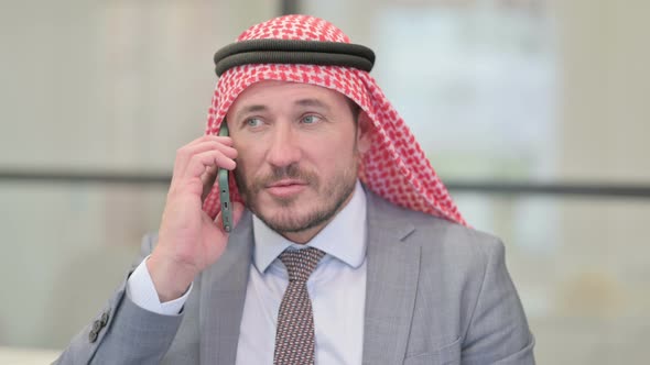 Portrait of Middle Aged Arab Businessman Talking on Phone alt