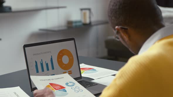 Young african male with laptop at work at home office. Working male with laptop screen alt
