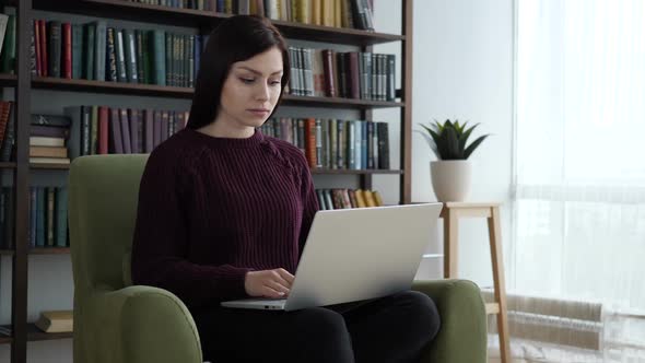 Casual Sitting Woman Closing Laptop and Leaving Sofa in Office alt