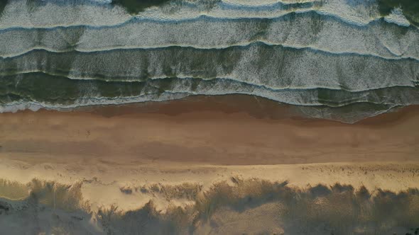 Landscape Wide View of Beautiful Beach with Dunes and Waves Crashing in White Foam, Aerial Overhead alt