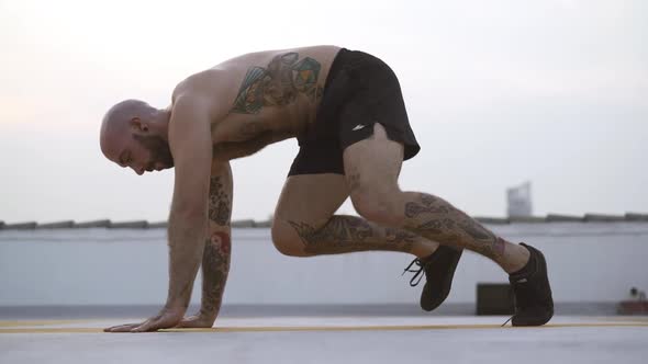 Male Yoga Practitioner Twisting His Body Side To Side Stretching His Legs alt
