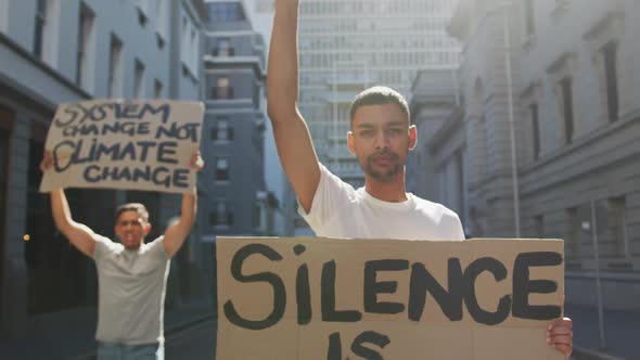 Two mixed race men on a protest march holding placards raising hands and shouting alt