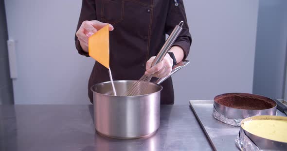 Female Pastry Chef Prepares Pastry in a Pot for Filling a Cake in a Professional Kitchen