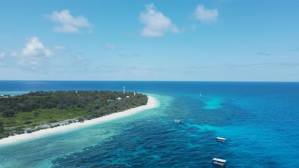 Island location surrounded by tropical blue ocean waters and a underwater reef system. Drone view alt