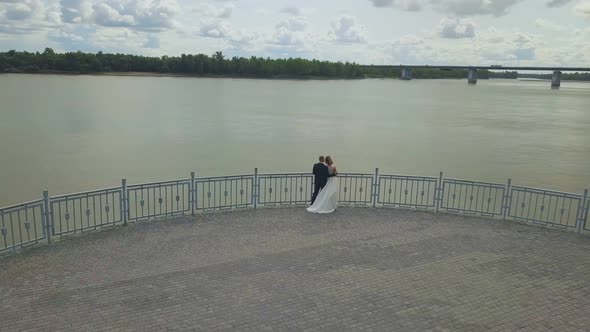 Just Married People on Viewpoint Above River Aerial View alt