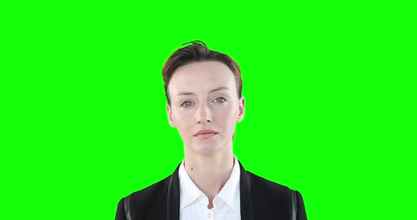 Caucasian woman looking at camera on green background